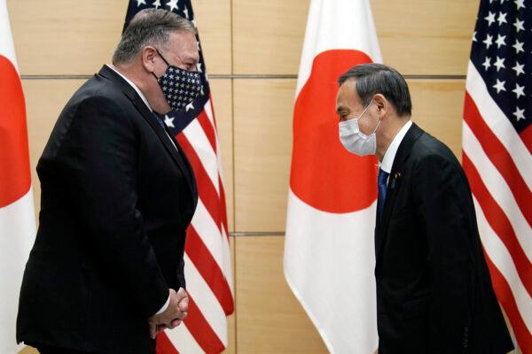 Japan's Prime Minister Yoshihide Suga, right, and U.S. Secretary of State Mike Pompeo, left, greet prior to their meeting at the prime minister's office in Tokyo on Oct. 6, 2020. Pompeo is in Japan to attend the four Indo-Pacific nations' foreign ministers meeting. (AP Photo/Eugene Hoshiko, Pool)