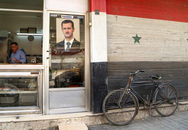 A picture of Syrian President Bashar al-Assad is seen on a door of a butcher shop, during a lockdown to prevent the spread of the coronavirus disease (COVID-19), in Damascus, Syria, on April 22, 2020. (Yamam Al Shaar/Reuters)