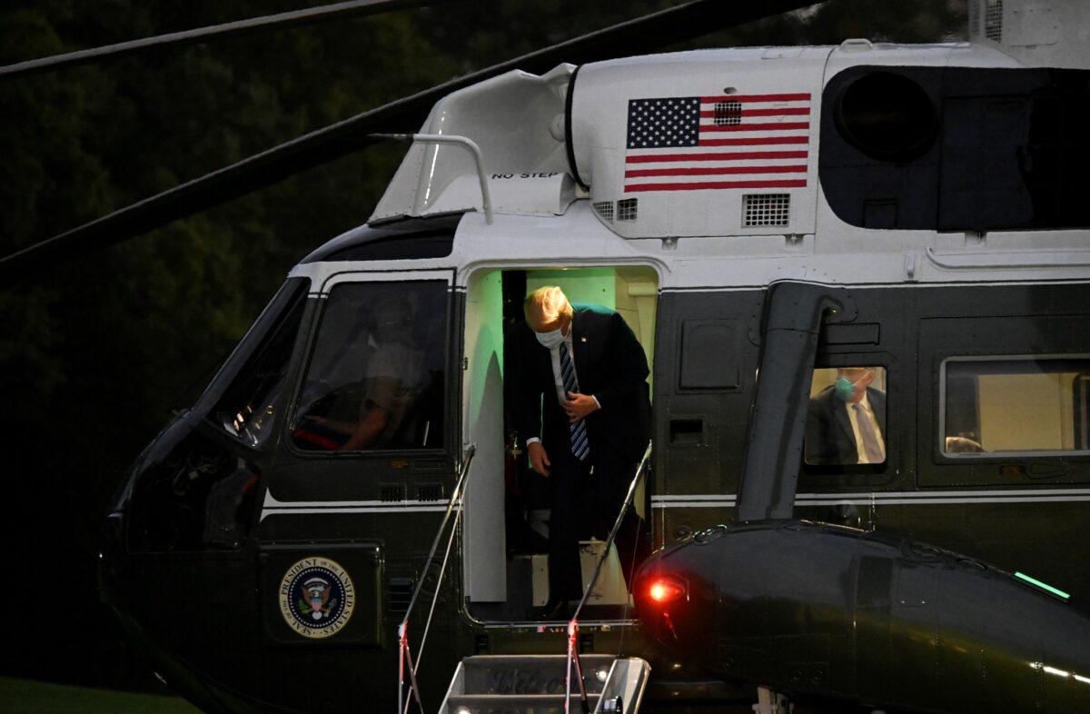 President Donald Trump disembarks from Marine One after the president returned from a fourth day of treatment for COVID-19 as he arrives on the South Lawn at the White House in Washington, Oct. 5, 2020. (Erin Scott/Reuters)