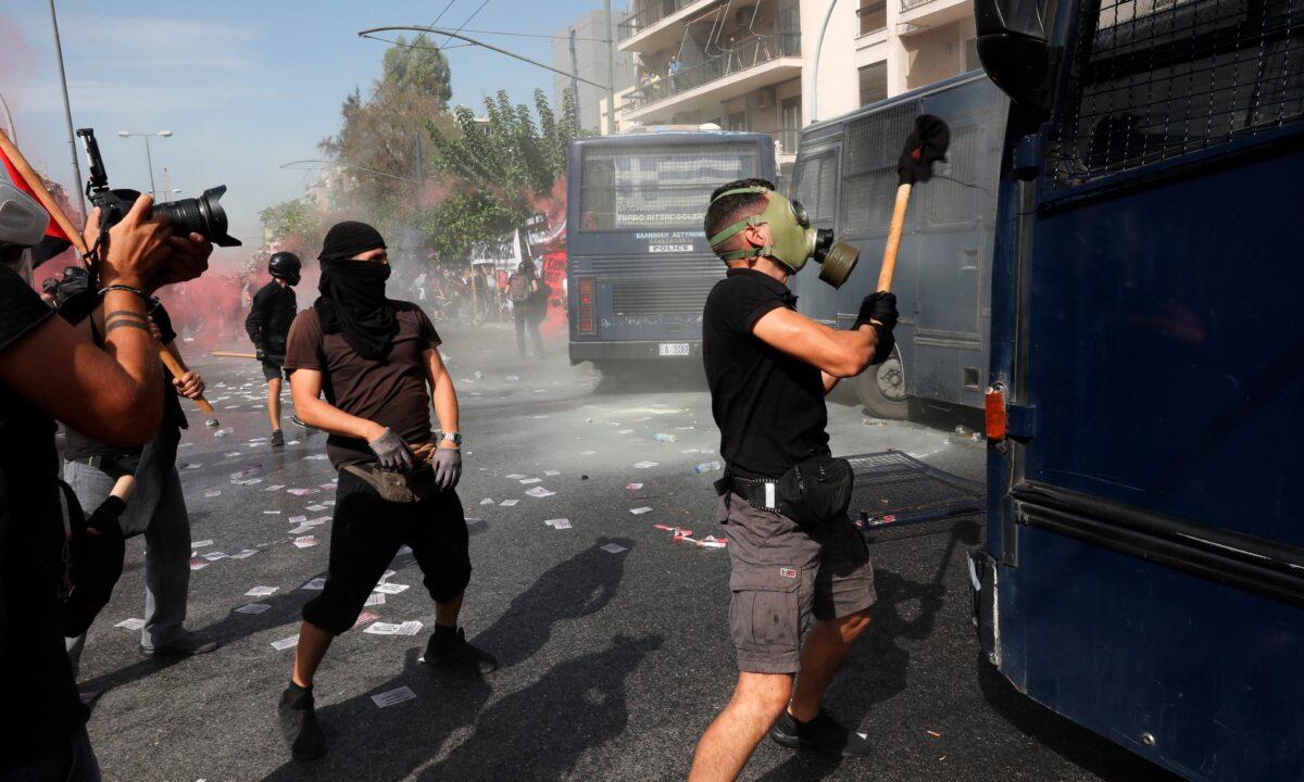 A masked protester tries to damage a police vehicle during scuffles outside the courthouse in Athens, on Oct. 7, 2020. (Yorgos Karahalis/AP Photo)