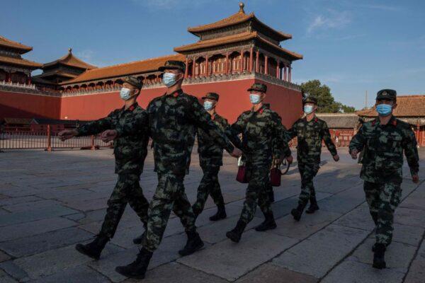 Paramilitary police officers wearing face masks march next to the entrance of the Forbidden City in Beijing on Sept. 20, 2020. (Nicolas Asfouri/AFP via Getty Images)