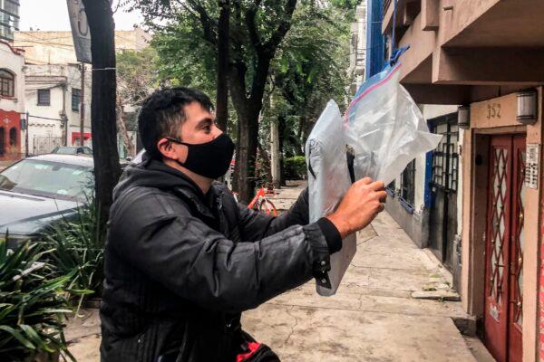 A delivery man leaves a package purchased on an e-commerce platform amid the COVID-19 coronavirus pandemic in Mexico City, on Sept. 29, 2020. (Pedro Pardo/AFP via Getty Images)