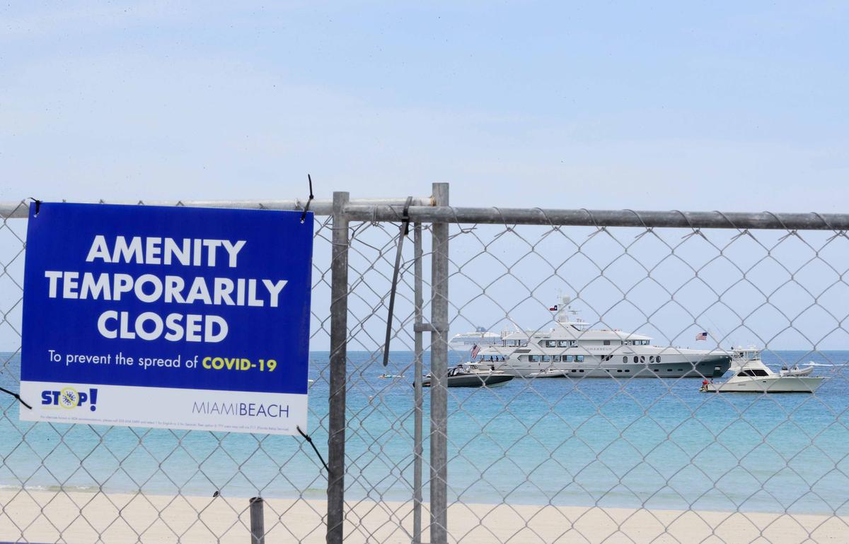 Boats are anchored off the beach as signage indicates that the beach is temporarily closed in South Pointe park on July 4, 2020, in the South Beach neighborhood of Miami Beach, Florida. (Cliff Hawkins/Getty Images)