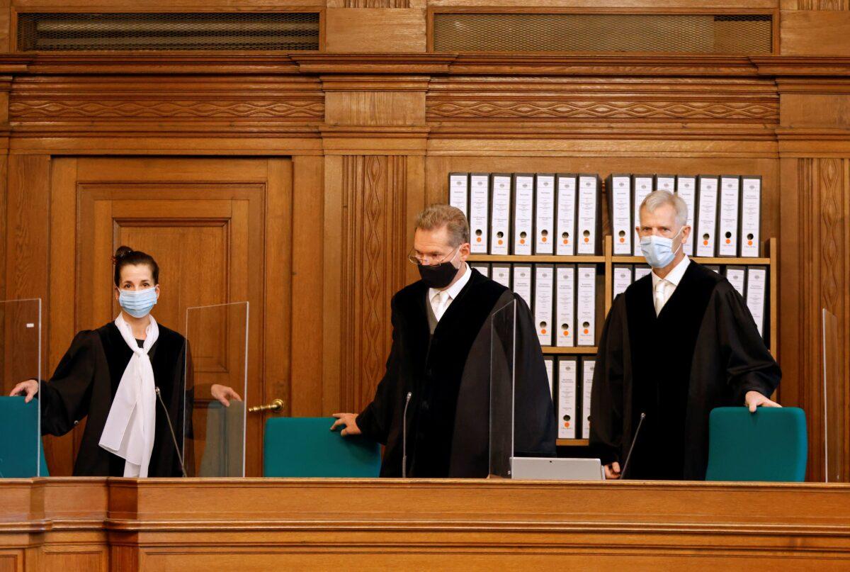 Judge Olaf Arnoldi (R) and colleagues take their seats in the courtroom at the beginning of the trial of defendant Vadim K., in Berlin, Germany, on Oct. 7, 2020. (Odd Andersen/Pool via Reuters)