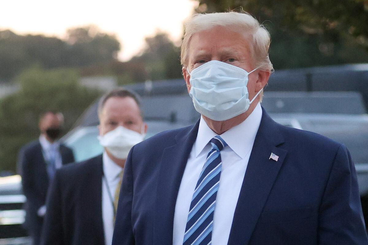 President Donald Trump looks over at reporters and photographers as he departs Walter Reed National Military Medical Center in Bethesda, Md., on Oct. 5, 2020. (Jonathan Ernst/Reuters)