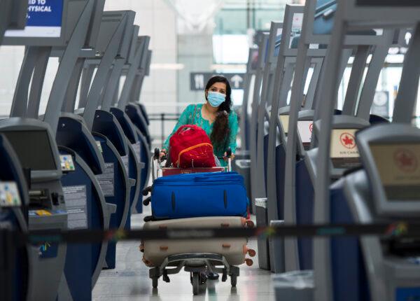A traveler walks between check-in kiosks at Toronto's Pearson International Airport for a "Healthy Airport" during the COVID-19 pandemic in Toronto on June 23, 2020. (Nathan Denette/The Canadian Press)