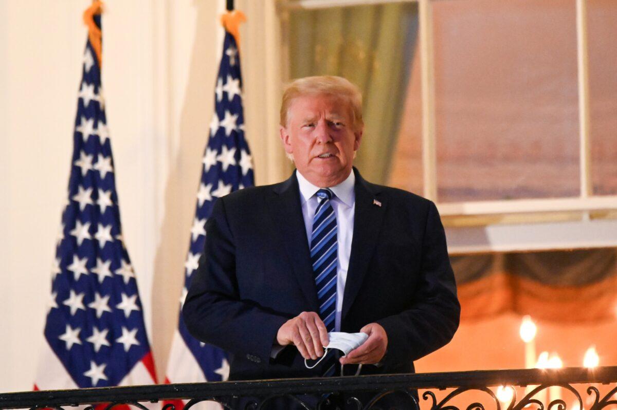 President Donald Trump poses on the Truman Balcony of the White House after returning from being hospitalized at Walter Reed Medical Center for COVID-19 treatment, in Washington, on Oct. 5, 2020. (Erin Scott/Reuters)