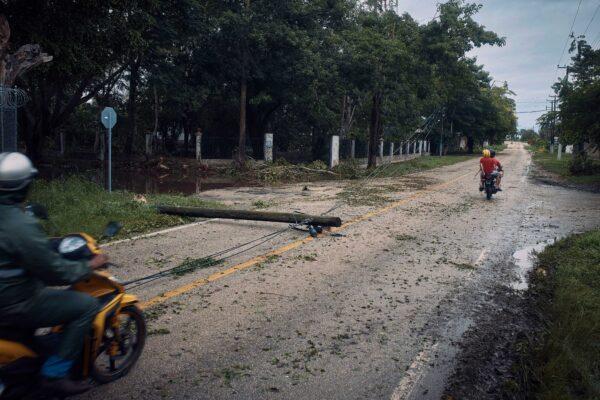 Motorcyclists ride past a power post toppled by Hurricane Delta in Tizimin, Mexico, on Oct. 7, 2020. (Andres Kudacki/AP Photo)