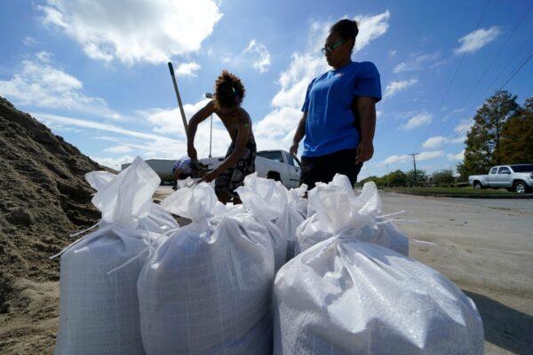 Stephanie Verrett and Jodie Jones fill sandbags to protect their home in anticipation of Hurricane Delta, in Houma, La., on Oct. 7, 2020. (Gerald Herbert/AP Photo)