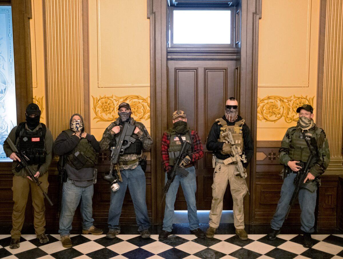 A militia group with no political affiliation from Michigan, including Pete Musico (R) who was charged Oct. 8, 2020 for his involvement in a plot to kidnap the Michigan governor, attack the state capitol building and incite violence, stands in front of the Governors office after protesters occupied the state capitol building during a vote to approve the extension of Gov. Gretchen Whitmer's stay-at-home order due to the COVID-19 outbreak, at the state capitol in Lansing, Mich., April 30, 2020. (Seth Herald/Reuters)