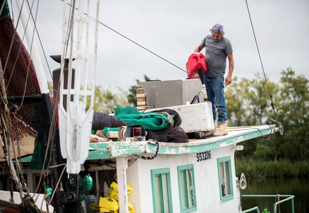 Timothy Schouest adds diesel to his boat's generator in preparation for Hurricane Delta at Bayou Carlin Cove, in Delcambre, La., on Oct. 8, 2020. (Leslie Westbrook/The Advocate via AP)