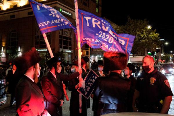 Orthodox Jews wave Trump flags as they gather in the Borough Park neighborhood of Brooklyn to protest against COVID-1) restrictions in New York, Oct. 7, 2020. (Yuki Iwamura/Reuters)