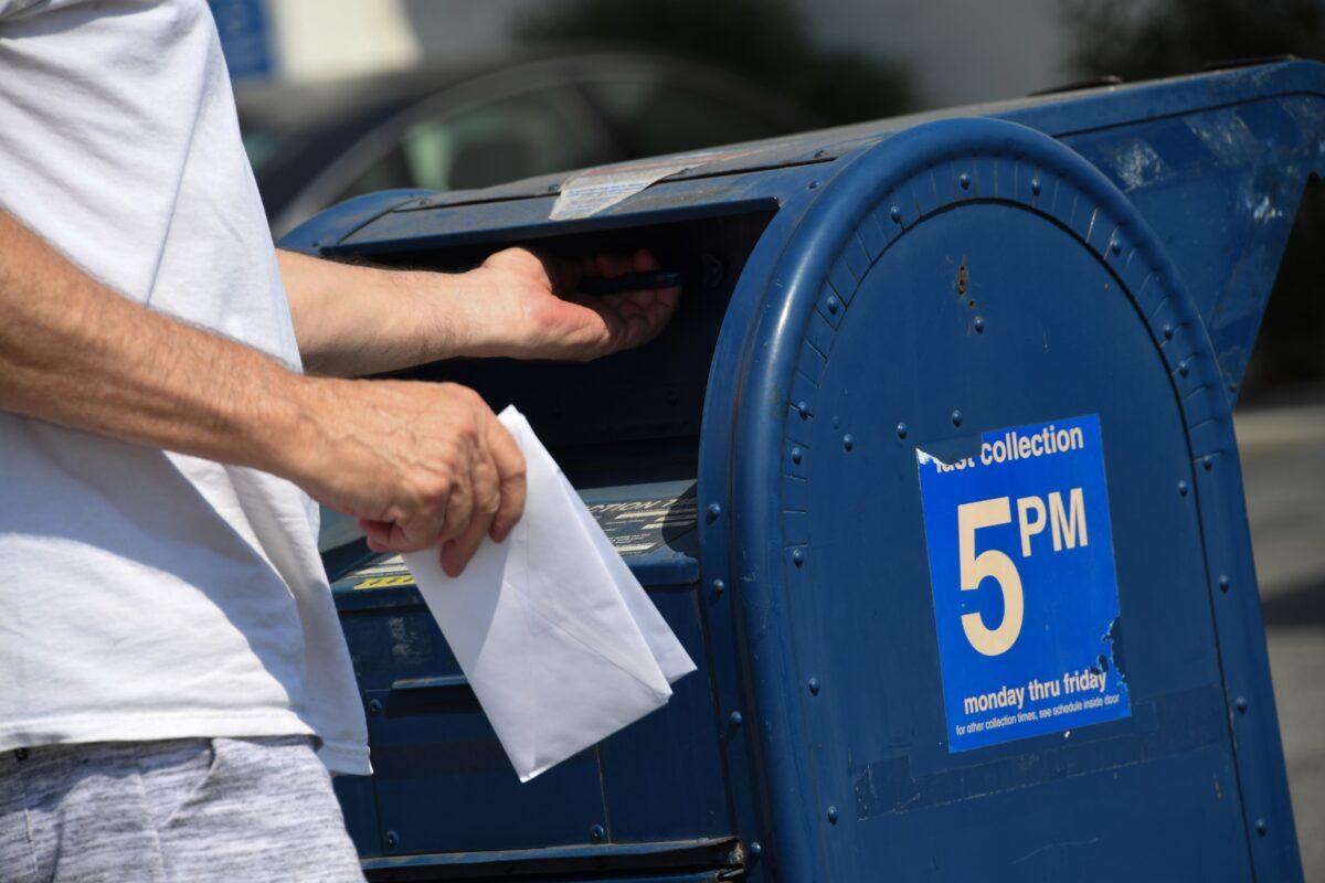 A person mails a letter at a mailbox outside a post office in Los Angeles, Calif., on Aug. 17, 2020. (Robyn Beck/AFP via Getty Images)