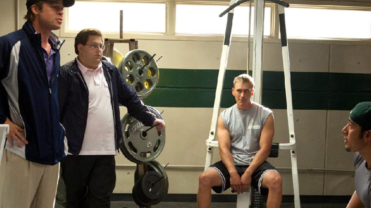 (L–R) Billy Beane (Brad Pitt) and Peter Brand (Jonah Hill) with players in the locker room, in "Moneyball." (Melinda Sue Gordon/Columbia TriStar Marketing Group, Inc.)