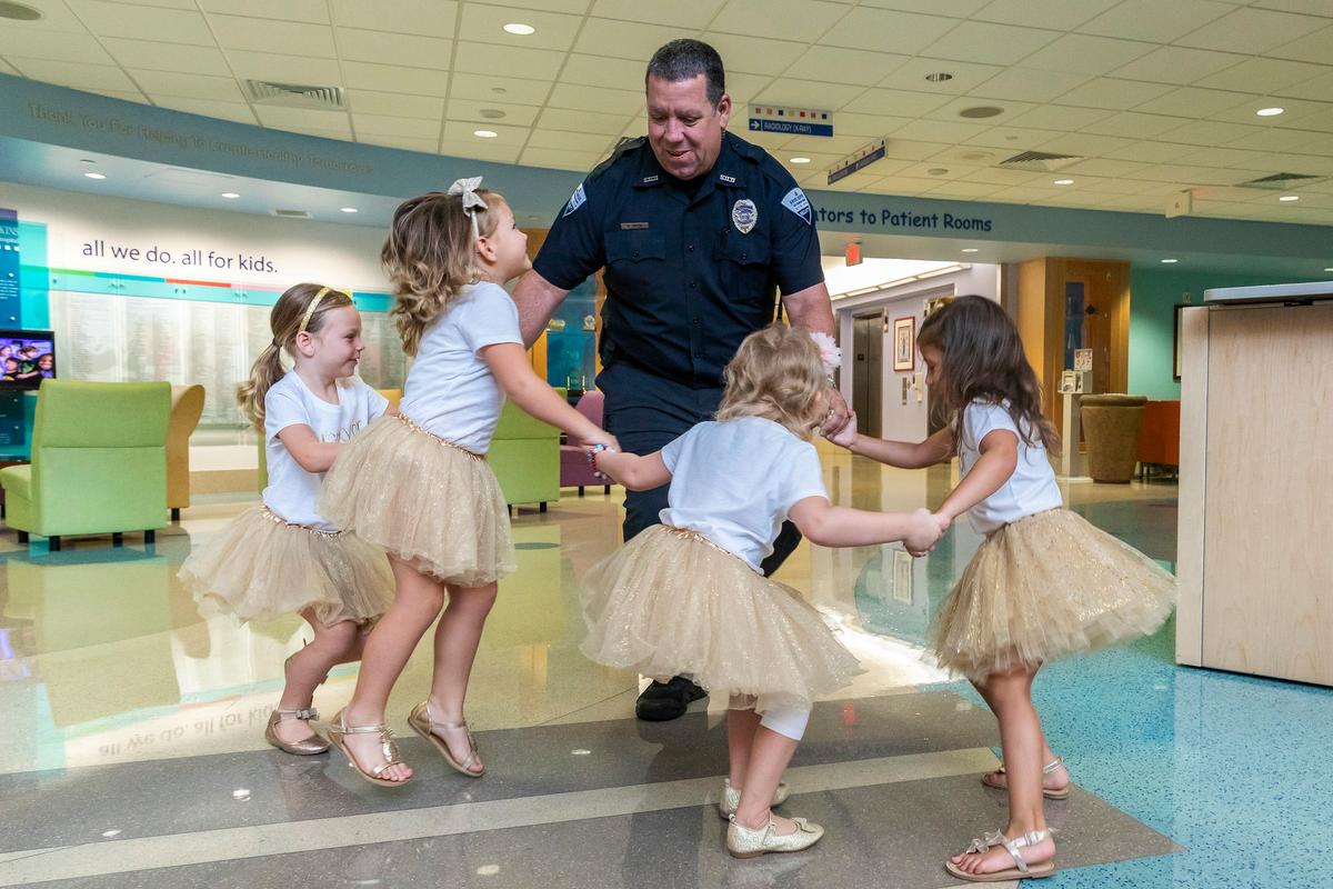 Security guard David Dean of Johns Hopkins All Children’s Hospital dances with McKinley Moore, Avalynn Luciano, Lauren Glynn, and Chloe Grimes at the hospital in St. Petersburg, Fla., Aug. 9, 2018. (Allyn DiVito/John Hopkins All Children's Hospital via AP)