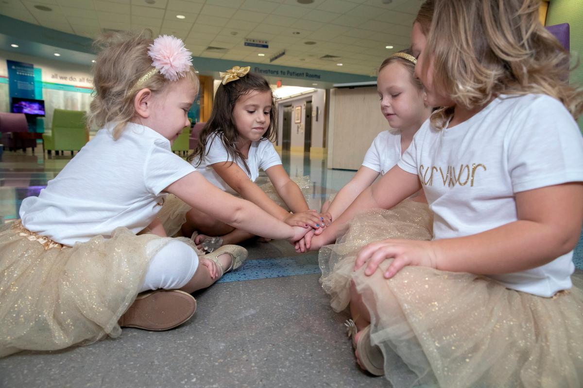 Lauren Glynn, Chloe Grimes, McKinley Moore, and Avalynn Luciano place their hands together at the hospital in St. Petersburg, Fla., Aug. 9, 2018. (Allyn DiVito/John Hopkins All Children's Hospital via AP)
