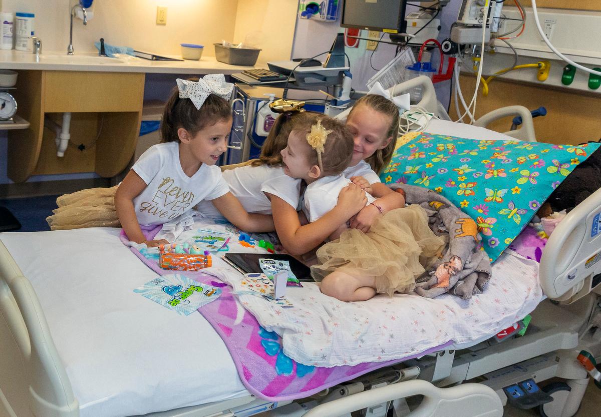 Lauren Glynn is visited by friends Chloe Grimes, Avalynn Luciano, and McKinley Moore in her room at the hospital in St. Petersburg, Fla., Aug. 28, 2019. (Allyn DiVito/John Hopkins All Children's Hospital via AP)