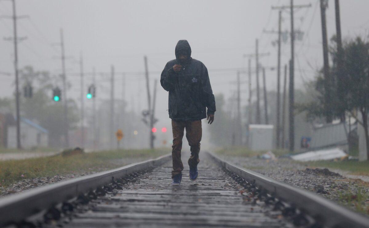 Desond Peter walks down a railroad track in search of an open store during Hurricane Delta in Lake Charles, La., on Oct. 9, 2020. (Jonathan Bachman/Reuters)