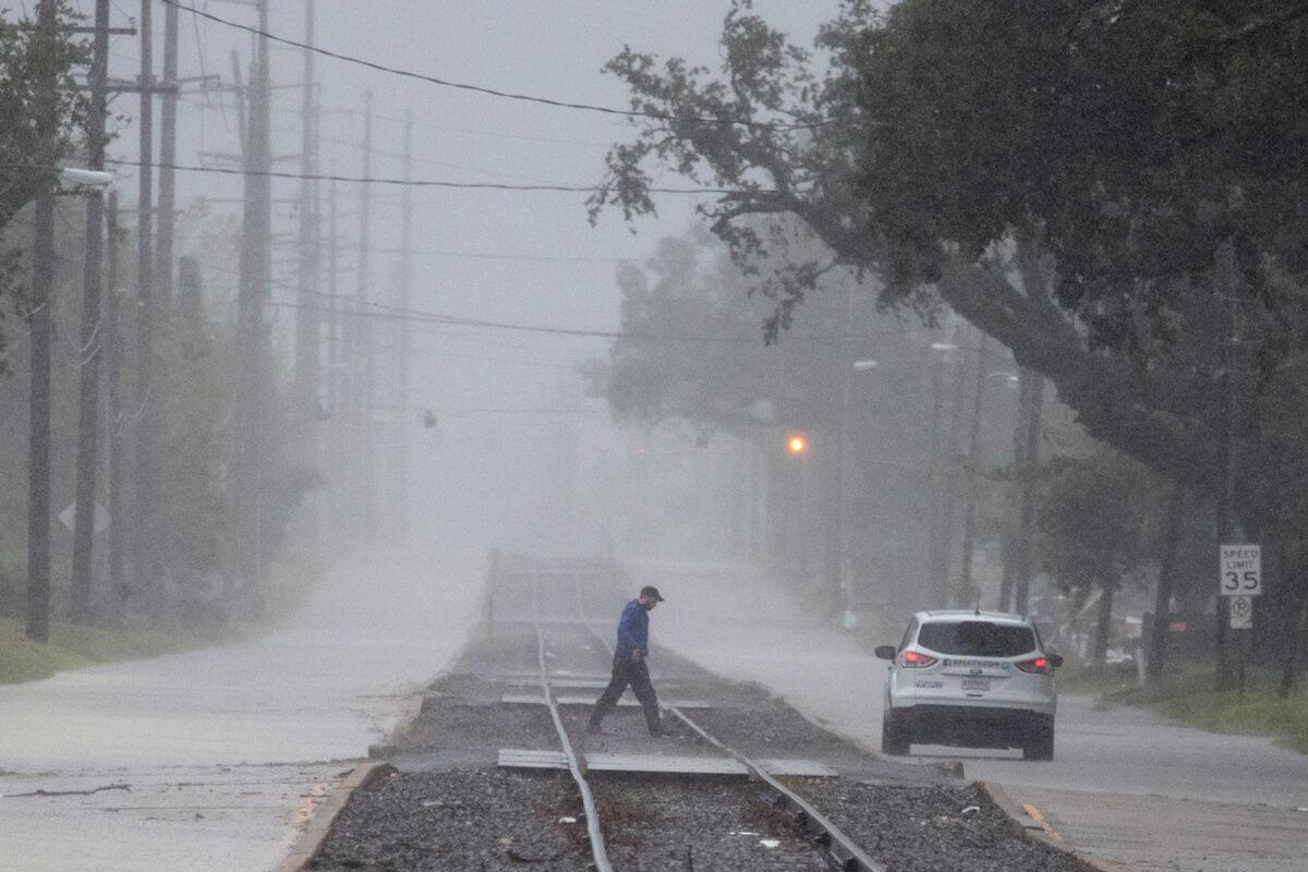  A man returns to his vehicle after checking road conditions during heavy rainfall ahead of the arrival of Hurricane Delta in Lake Charles, La., Oct. 9, 2020. (Adrees Latif/Reuters)