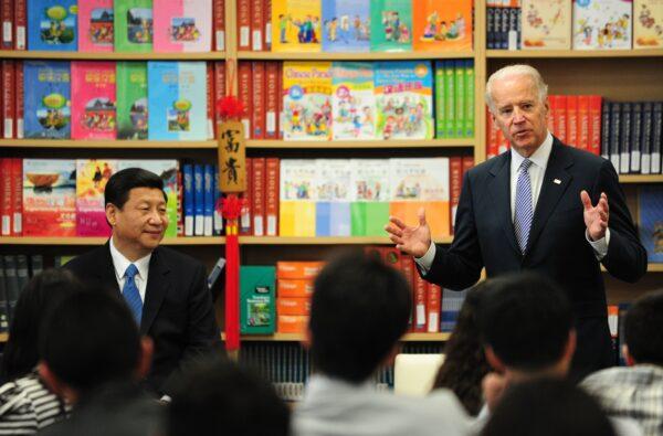 Then-U.S. Vice President Joe Biden (R) speaks to students as his visiting Chinese counterpart Xi Jinping (L) listens during a visit to the International Studies Learning School in Southgate, outside of Los Angeles, on Feb. 17, 2012. (FREDERIC J. BROWN/AFP via Getty Images)