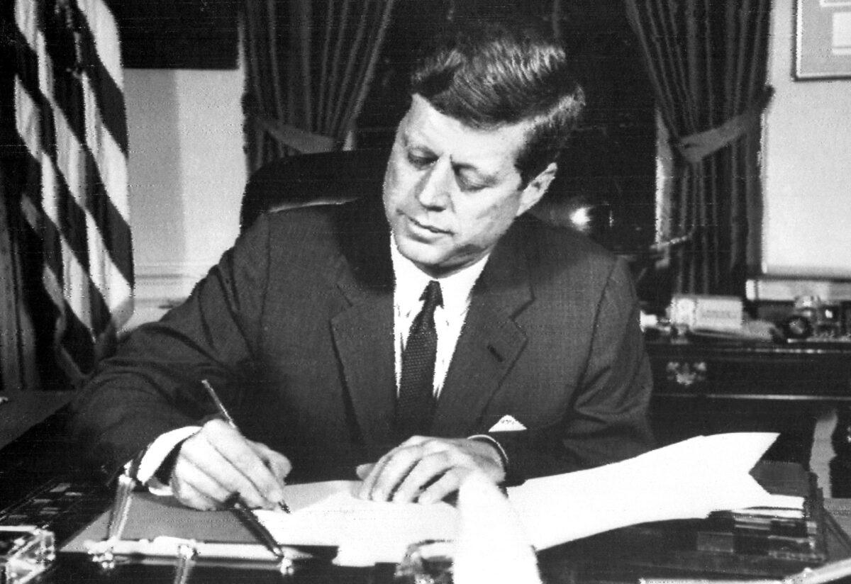 U.S. President John F. Kennedy signs the order for a naval blockade of Cuba during the Cuban Missile Crisis, on Oct. 24, 1962. (AFP via Getty Images)
