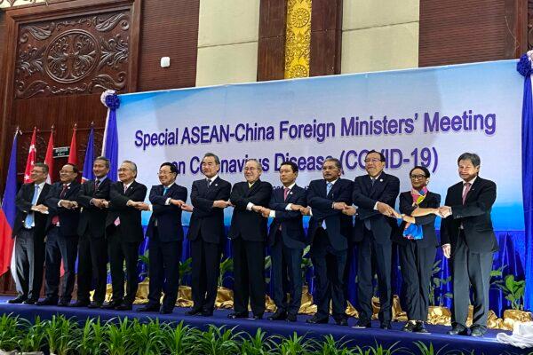 ASEAN Secretary-General Lim Jock Hoi (R) and foreign ministers shake hands on stage at a summit between China and ASEAN (Association of Southeast Asian Nations) on the COVID-19 coronavirus in Vientiane, Laos, on Feb. 20, 2020. (Dene-Hern Chen/AFP via Getty Images)