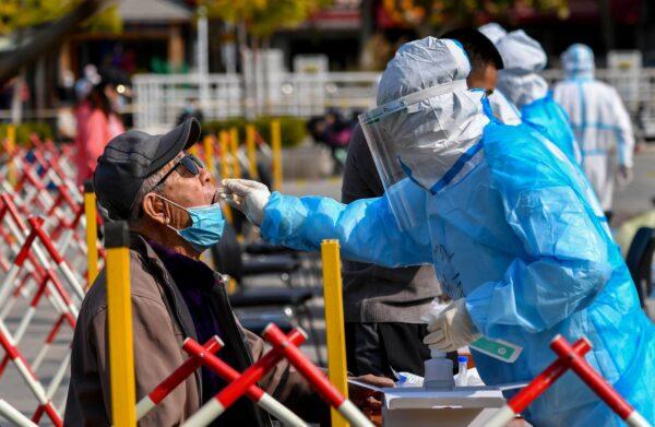 A health worker takes a swab from a resident to be tested for the COVID-19 in Qingdao, eastern China’s Shandong Province on Oct. 12, 2020. (STR/AFP via Getty Images)