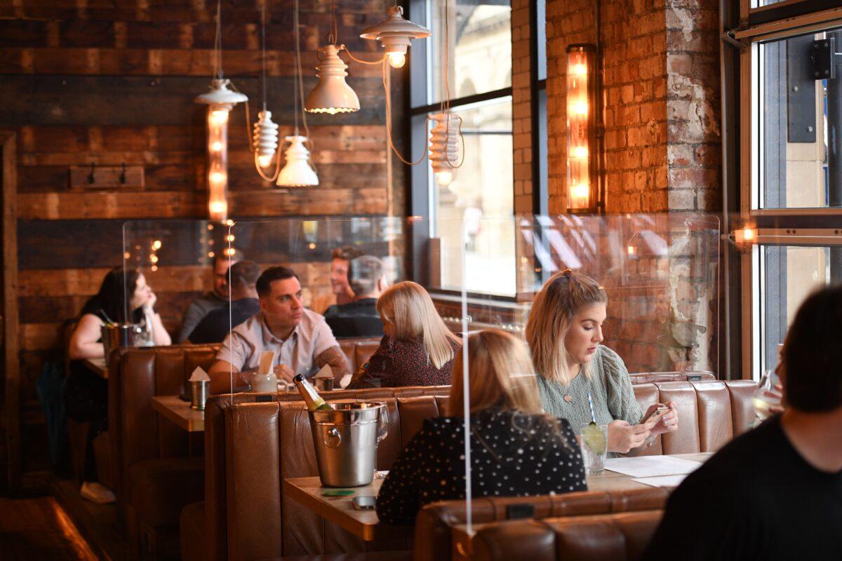 Customers sit in booths separated by perspex screens in an Alberts Schloss bar in Manchester, England, on July 4, 2020. (Oli Scarff/AFP via Getty Images)