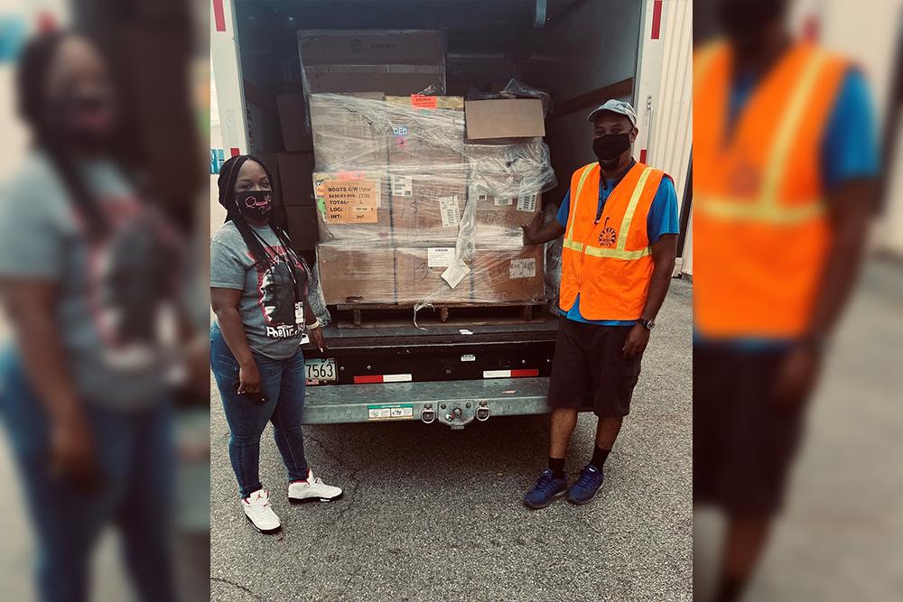 Disposal service representative LaVette Rush (L) and customer Hosea Williams (R) as he accepts 189 pairs of boots at DLA Disposition Services at Warner Robins July 28 that will be used to help the homeless. (<a href="https://www.dvidshub.net/image/6321664/picking-up-boots">Sammie Sanders</a>/DLA Disposition Services/DVIDSHUB)