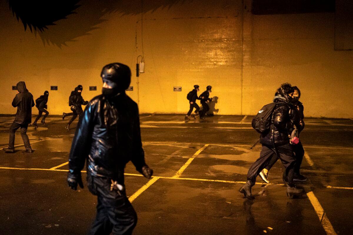 People flee from police officers during a riot in Portland, Ore., Oct. 11, 2020. (Nathan Howard/Getty Images)