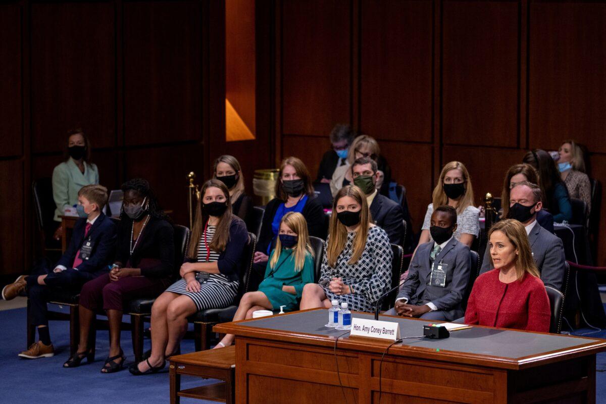 Supreme Court nominee Judge Amy Coney Barrett responds to a question as her children and family sit behind her during the second day of her confirmation hearing before the Senate Judiciary Committee on Capitol Hill in Washington on Oct. 13, 2020. (Shawn Thew/Pool via Reuters)