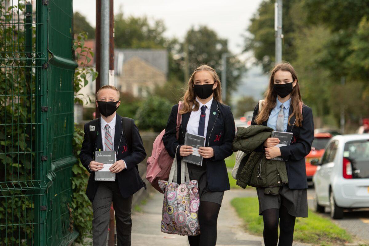 Pupils wearing facemasks as a precaution against the transmission of the CCP virus arrive to attend Moor End Academy in Huddersfield, northern England on Sept. 11, 2020. (Oli Scarff/AFP via Getty Images)