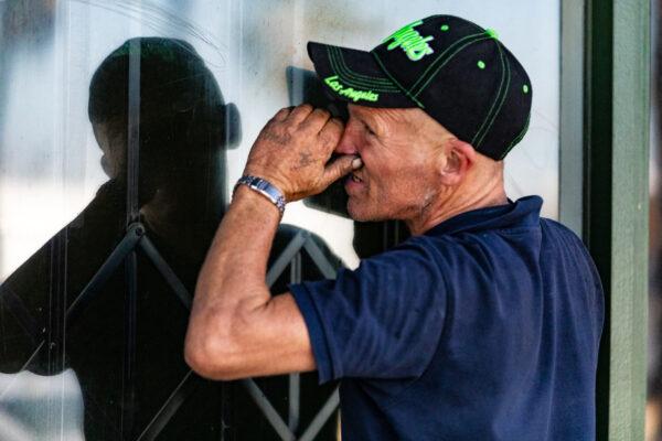 A man looks through the front window of a closed hydroponics store that housed an illegal gambling operation in Anaheim, Calif., on Oct. 14, 2020. (John Fredricks/The Epoch Times)