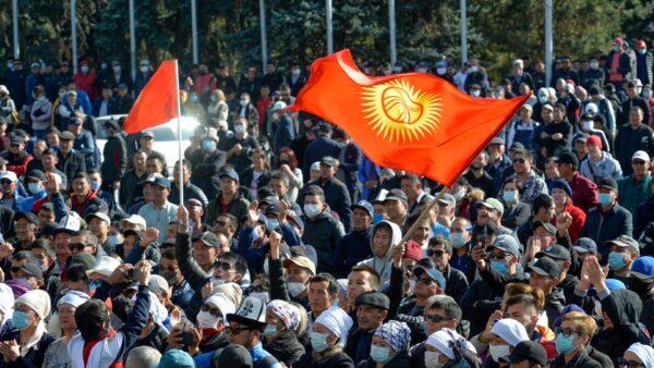  Protesters react waving Kyrgyz national flags as they wait for Kyrgyz Prime Minister Sadyr Zhaparov speech in front of the government building in Bishkek, Kyrgyzstan, on Oct. 14, 2020. (Vladimir Voronin/AP Photo)