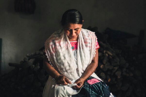 A Mexican artisan in Puebla counts the stitches in her hand embroidery. (Someone Somewhere)