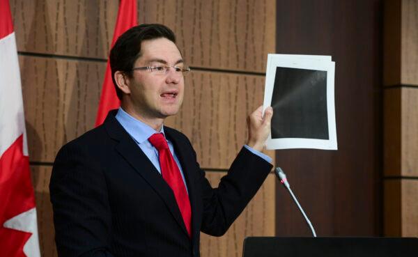 Conservative MP Pierre Poilievre holds up redacted documents during a press conference on Parliament Hill on Aug. 19, 2020. (Sean Kilpatrick/The Canadian Press)