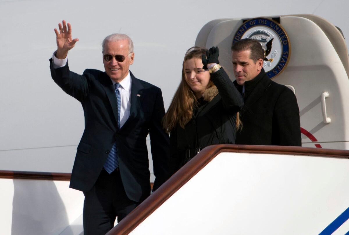Then Vice President Joe Biden waves as he walks out of Air Force Two with his granddaughter, Finnegan Biden (center), and son Hunter Biden (right) upon their arrival in Beijing on Dec. 4, 2013. (Ng Han Guan/AFP via Getty Images)