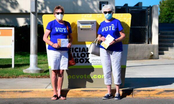 Voters Jeannie Osbourne (L) and Judy Nader (R) stand beside an official Orange County ballot drop box as they prepare to cast their ballots for the 2020 elections at the Orange County Registrar's Office in Santa Ana, Calif., on Oct. 13, 2020. (Frederic J. Brown/AFP via Getty Images)