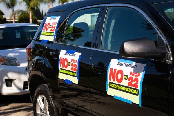 Signs opposing Proposition 22, a ballot measure that would allow ride-share workers to be classified as independent workers instead of employees, are taped to a vehicle participating in a car rally against the measure in Orange, Calif., on Oct. 16, 2020. (John Fredricks/The Epoch Times)