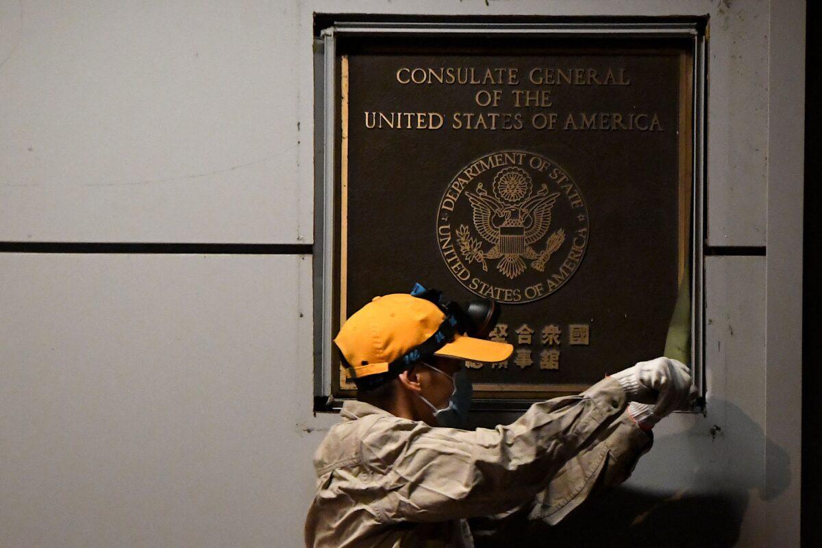 A worker attempts to remove the wall insignia of the U.S. Consulate in Chengdu, southwestern China's Sichuan province, on July 26, 2020. (Noel Celis/AFP via Getty Images)