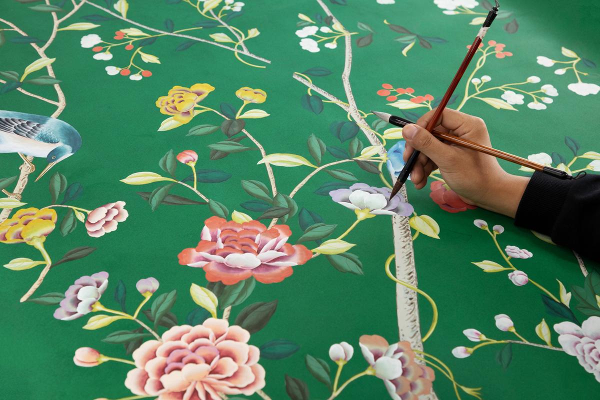 An artist working with two brushes in one hand. (Courtesy of de Gournay)