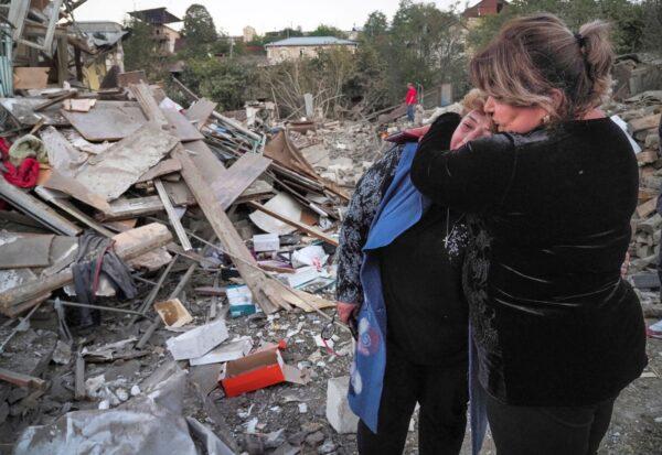A neighbour comforts home owner Lida Sarksyan (L) near her house destroyed by shelling from Azerbaijan's artillery during a military conflict in Stepanakert, the separatist region of Nagorno-Karabakh, on Oct. 17, 2020. (AP Photo)