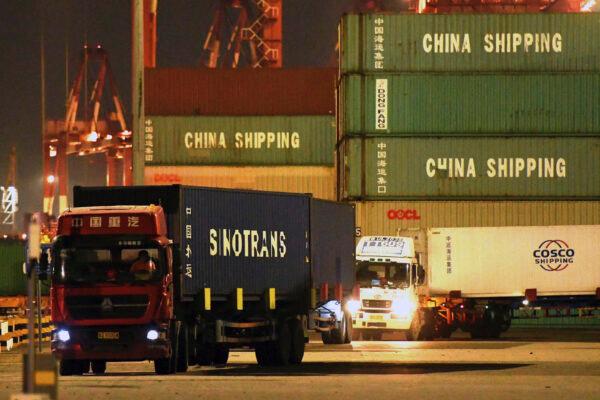 Trucks transport shipping containers at a dockyard in Qingdao in eastern China, on Sept. 25, 2020. (Chinatopix Via AP)