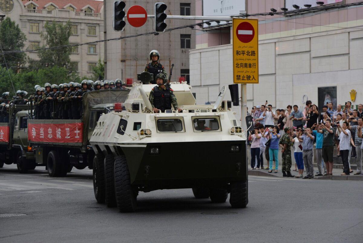 Chinese paramilitary police ride in trucks and an armored personnel carrier during a "show of force" ceremony in Urumqi, northwestern China’s Xinjiang region on June 29, 2013. (Mark Ralston/AFP via Getty Images)