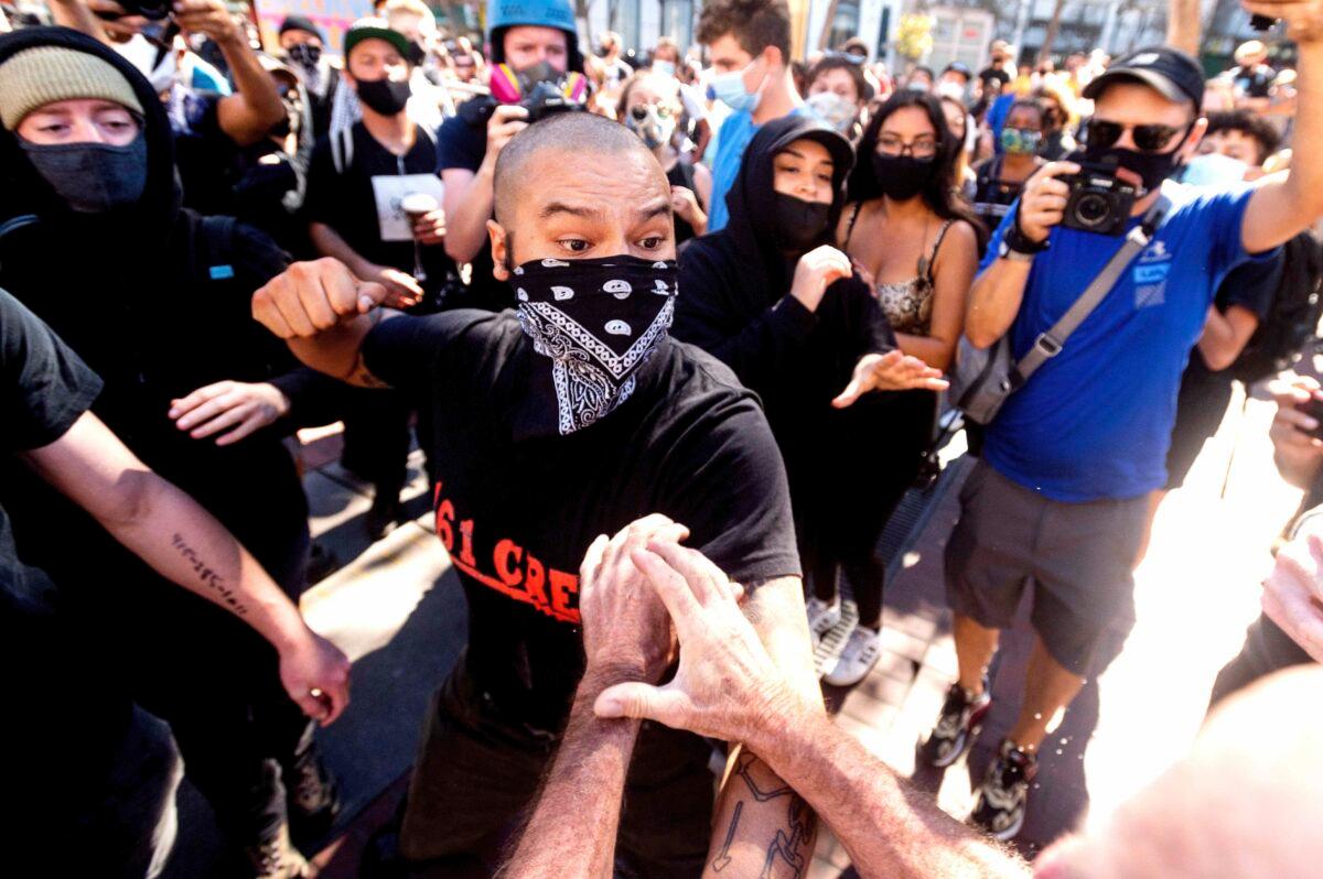 A counterprotester prepares to hit conservative free speech rally organizer Philip Anderson in San Francisco, Calif., on Oct. 17, 2020. (AP Photo/Noah Berger)