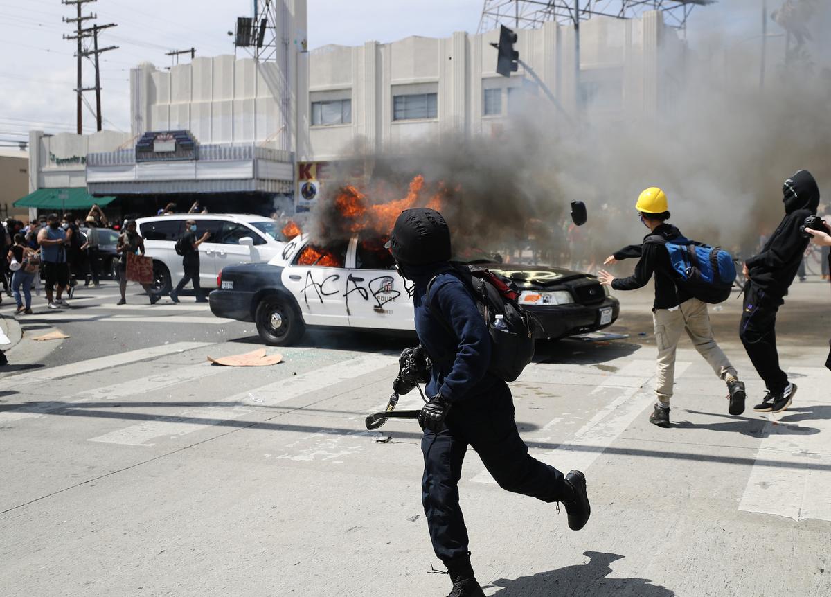 An LAPD vehicle is set on fire by rioters in Los Angeles, on May 30, 2020. (Mario Tama/Getty Images)