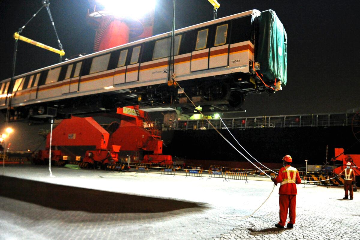 Workers load an exported subway train cartridge to a container ship at a dockyard in Qingdao in east China's Shandong province on Sept. 25, 2020. (Chinatopix via AP)