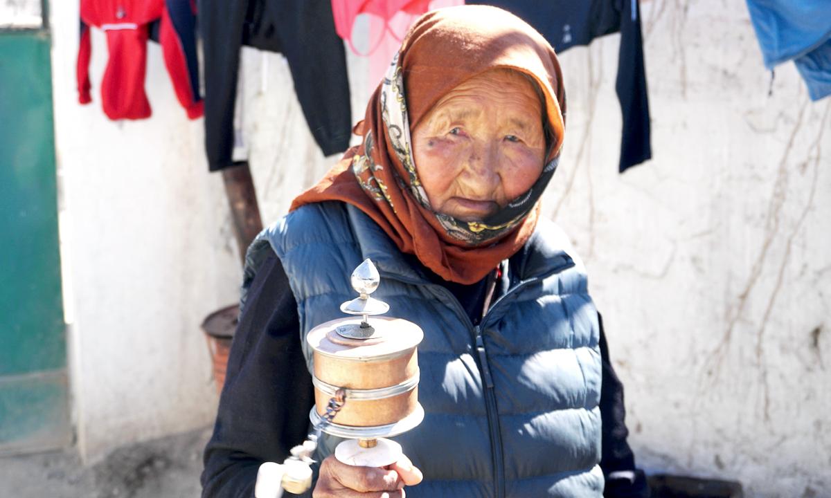 Kalsang Lhamo, 85, rotates her prayer wheel in the Tibetan refugee colony of Agling, in Leh, India, on Oct. 18, 2020 (Venus Upadhayaya/Epoch Times)