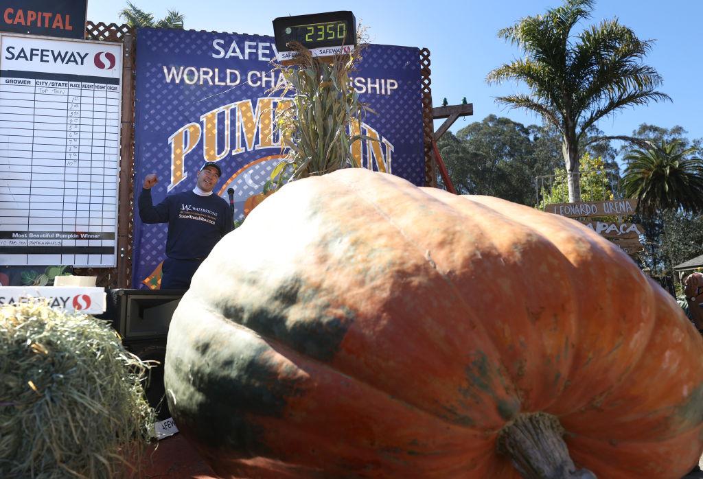 Travis Gienger pumps his fist as he stands next to his 2,350-pound pumpkin during the Safeway World Championship Pumpkin Weigh-Off on Oct. 12, 2020, in Half Moon Bay, Calif. (Justin Sullivan/Getty Images)