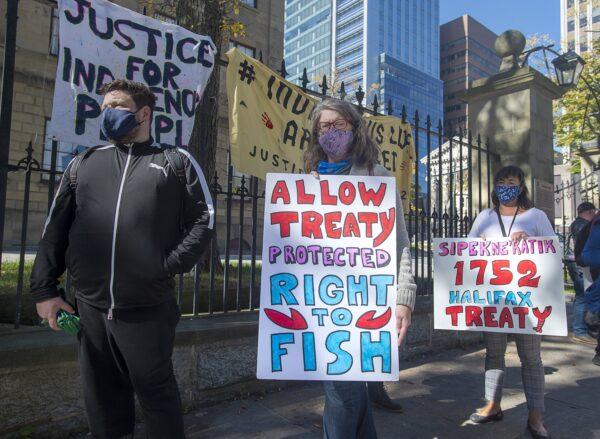 Supporters stand in line holding signs as Cheryl Maloney, a member of the Sipekne'katik First Nation and an activist, sells lobster outside the legislature in Halifax on Oct. 16, 2020. (The Canadian Press/Andrew Vaughan)